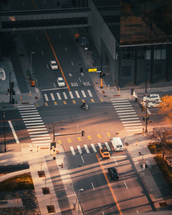Wide aerial view of a busy city intersection during sunset in Minneapolis, highlighting urban life and traffic.